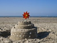 3204703-a-sand-castle-decorated-by-seashells-and-a-spinning-red-pinwheel-toy-windmill.jpg